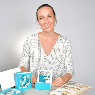 Présentation de cartes pop-up bleues et blanches à une table de travail.